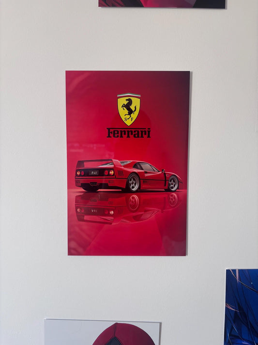 Tableau métallique brillant d'une Ferrari F40 rouge avec son logo officiel, posée sur une surface réfléchissante sur fond dégradé rouge.