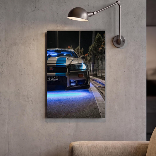 A framed photograph of a police car with blue lights on the front, mounted on a wall next to a lamp.