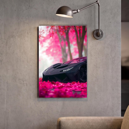 A framed image of a black sports car parked on a bed of pink flowers, with a lamp fixture above it.